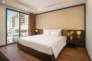 a bedroom with a large bed and a large window at Palazzo Boutique Hotel in Danang