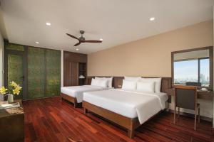 a bedroom with two beds and a desk at Palazzo Boutique Hotel in Danang