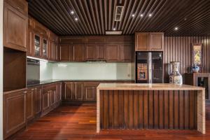 a large kitchen with wooden cabinets and a island at Palazzo Boutique Hotel in Danang