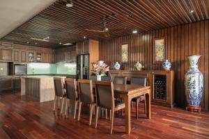a kitchen with a table and chairs and a vase at Palazzo Boutique Hotel in Danang