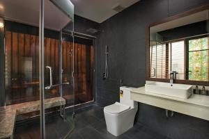 a bathroom with a toilet and a shower and a sink at Palazzo Boutique Hotel in Danang