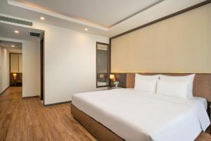 - un grand lit blanc dans une chambre d'hôtel dans l'établissement Palazzo Boutique Hotel, à Đà Nẵng