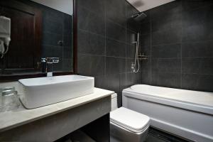a bathroom with a white sink and a toilet at Palazzo Boutique Hotel in Da Nang