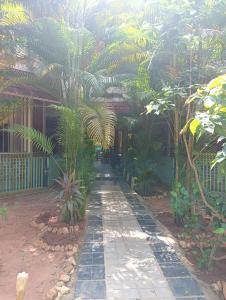 un jardín con palmeras y una pasarela en Smiley Resorts, en Auroville