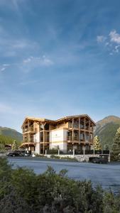 a large building with mountains in the background at Leni Mountain Lodge in Sölden