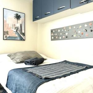 ル・アーヴルにあるPetit studio plage Le galet bleuのベッドルーム1室(青い毛布付きのベッド1台付)