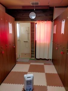 uma casa de banho com chuveiro e um relógio na parede em G-4 Gramping Sauna 白馬森のわさび農園 em Hakuba