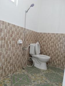 a bathroom with a toilet with a shower at GmL Lodge House in Daanbantayan