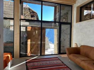 ein Wohnzimmer mit einem großen Fenster mit Bergblick in der Unterkunft Bijoux in the Swiss mountains in Vna