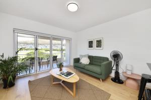 a living room with a green couch and a table at Mouille Point Apartments in Cape Town