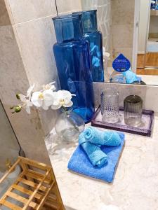 een badkamerbar met blauwe glazen vazen en handdoeken bij Fantastic Holiday Home Ocean View Quality Central Location in Gold Coast