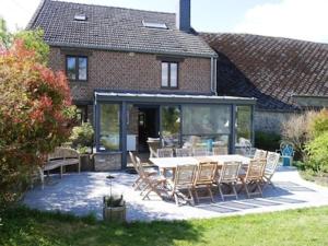 a patio with a table and chairs in front of a house at Gîte 7ici in Blaimont