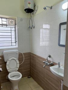 a bathroom with a toilet and a sink at Sreemati - A Tranquil Villa in Shānti Niketan