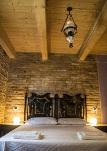 a bedroom with a bed with a stone wall at Le Viole B&B in Mergo