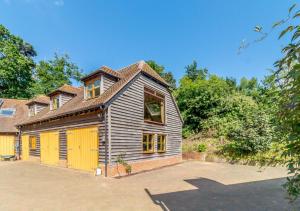 an old wooden house with a yellow garage at Vale View in Hollesley