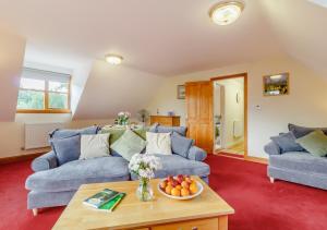 uma sala de estar com dois sofás azuis e uma mesa em Vale View em Hollesley