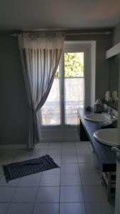 een badkamer met 2 wastafels en een groot raam bij Villa Bugatti in Le Mans