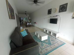 a living room with a couch and a table at AA HOMESTAY TAWAU in Kampong Parit