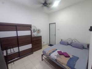 a bedroom with a large bed and a dresser at AA HOMESTAY TAWAU in Kampong Parit