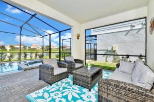 eine Terrasse mit Korbmöbeln und einem Pool in der Unterkunft Top Villas - Solterra Resort 805 in Davenport