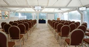 a room with rows of chairs and a screen at Relais Corte Degli Aragonesi in Ischia