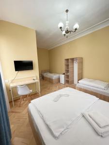 a room with two beds and a desk and a television at Guest House Top Floor in Telavi