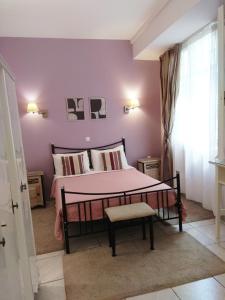 1 dormitorio con 1 cama con pared de color rosa en Filyra Pension, en Nauplia