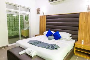 sypialnia z dużym łóżkiem z niebieskimi poduszkami w obiekcie Nelson Mandela Gardens w mieście Okpanam