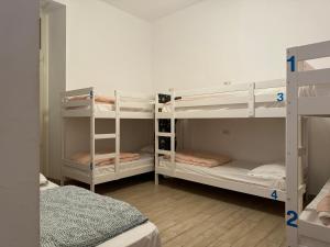 a room with two bunk beds and a room with two beds at Hostel Mancini Naples in Naples