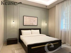 a bedroom with a large bed with white sheets at Kease Al-Mutamarat A-12 Timeless History AZ11 in Riyadh