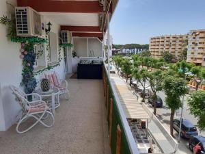 a balcony with chairs and tables on a building at Apartamento Pineda in La Pineda