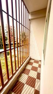Elle comprend un balcon avec un sol en damier et une grande fenêtre. dans l'établissement Kargil Stays- Dedicated 1BHK Flat with Balcony, à Bangalore