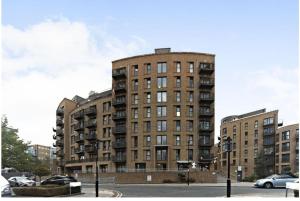 a tall building with cars parked in a parking lot at Superb Apartment CR0 in Croydon