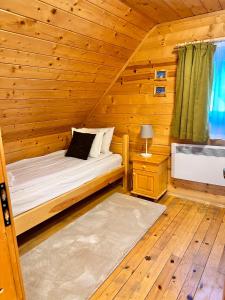 a bedroom with a bed in a wooden cabin at Alpine ski chalet Borovets with sauna in Borovets