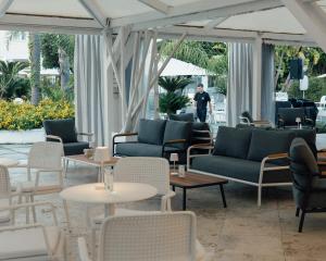 a lobby with couches and tables and a man in the background at Relais Corte Degli Aragonesi in Ischia