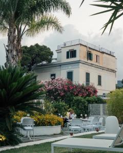 a building with tables and chairs in front of it at Relais Corte Degli Aragonesi in Ischia
