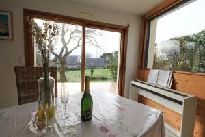 een tafel met twee flessen en glazen en een piano bij Entre ciel et mer - La maison de la pointe in Trégunc
