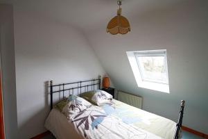 een slaapkamer met een bed en een raam bij Entre ciel et mer - La maison de la pointe in Trégunc