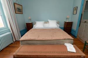 a bedroom with a large bed with a ottoman in it at Domaine de Montclair in Pommiers