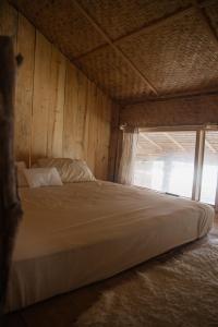 a bed in a wooden room with a window at rk.homestay in Rantepao