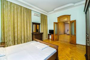 ein Schlafzimmer mit einem Bett und einem TV in der Unterkunft Big Apartment Saray in Baku