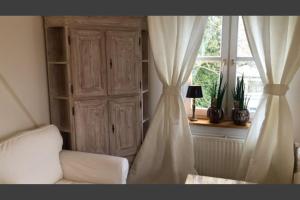 ein Wohnzimmer mit einem weißen Sofa und einem Fenster in der Unterkunft Ferienwohnung 20 im süßen Stadtkern von Sasel in Hamburg