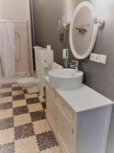 ein Badezimmer mit einem Waschbecken, einem WC und einem Spiegel in der Unterkunft Mehrbett-Apartment 4 Citynah, einfache Ausstattung in Hamburg