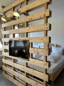 eine Holzwand mit einem TV im Schlafzimmer in der Unterkunft Studio-Apartment Shabby 47 Citynah, Retro & modern in Hamburg