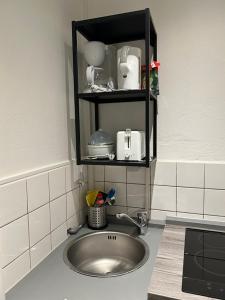 um lavatório numa cozinha com uma prateleira por cima em Gästezimmer 11 Citynah, Küche & Bad extern em Hamburgo