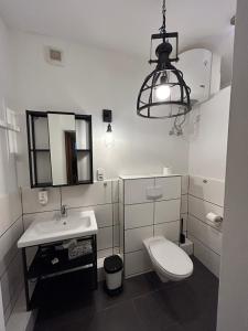 uma casa de banho com um WC, um lavatório e uma luz em Ferienwohnung Bauernliebe 43 Citynah, urban Cowboystyle em Hamburgo
