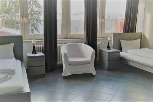 1 Schlafzimmer mit 2 Betten und einem weißen Stuhl in der Unterkunft Mehrbett-Apartment 3 Citynah, einfache Ausstattung in Hamburg