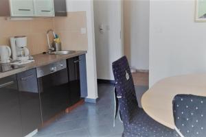 eine Küche mit einem Tisch und Stühlen im Zimmer in der Unterkunft Mehrbett-Apartment 3 Citynah, einfache Ausstattung in Hamburg