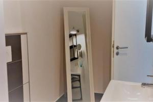ein weißes Badezimmer mit einem Spiegel und einem Waschbecken in der Unterkunft Mehrbett-Apartment 3 Citynah, einfache Ausstattung in Hamburg
