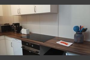 a kitchen with white cabinets and a counter top at Studio-Apartment Rockabilly 45 Citynah 60er Style in Hamburg +2 photos